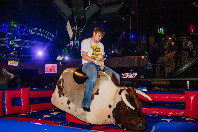 Feel the excitement in the air as friends take on the challenge of the mechanical bull at Stampede Houston! #HoustonNightlife #NightclubFun #StampedeHouston