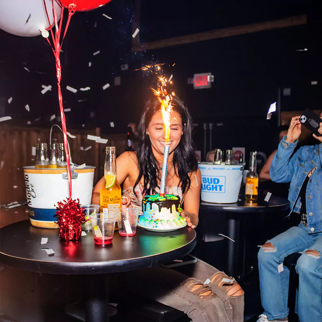 Birthday cake and champagne on a nightclub table in Houston
